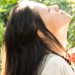 woman standing while closing her eyes and looking up